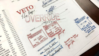 An override stamp is seen on legislation limiting LGBTQ+ classroom instruction in the early grades, after North Carolina state lawmakers override Democratic Gov. Roy Cooper's veto, Wednesday, Aug. 16, 2023, in Raleigh, N.C. The Republican-led General Assembly overrode the governor’s vetoes of the legislation and other bills touching on gender in sports and gender-affirming medical treatments. (AP Photo/Hannah Schoenbaum)