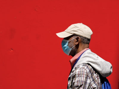 A pedestrian wearing a protective mask as a precaution against the spread of the coronavirus walks in Philadelphia, Friday, April 22, 2022. (AP Photo/Matt Rourke)